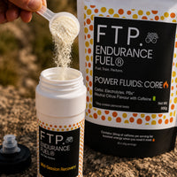 Scooping Power Fluids Core neutral citrus drink mix powder into a bottle before a session